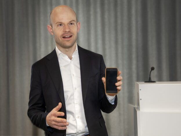 Johan Eriksson håller upp en telefon
